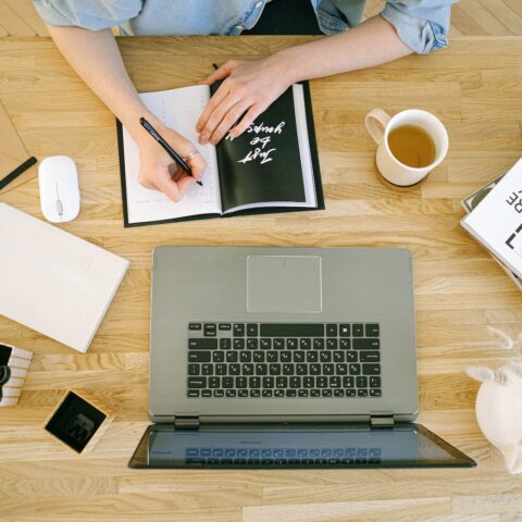 birdseye view of someone taking notes off a computer