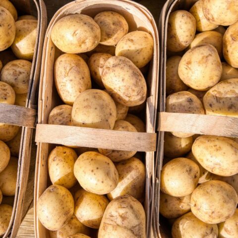 From above, potatoes in four wooden baskets.