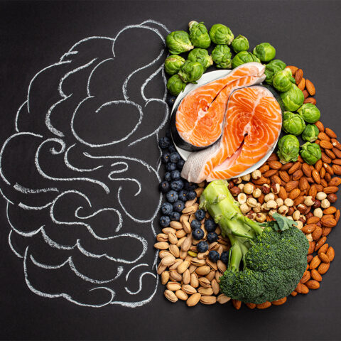 Brain concept art divided between a chalk drawing and assortment of brain-healthy foods