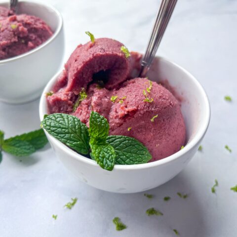 lime cherry sherbert in a bowl with a spoon