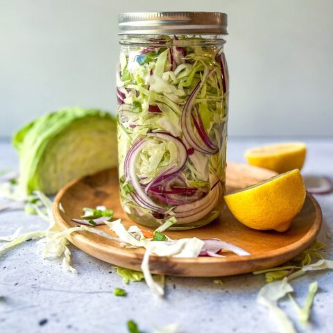 Low-sodium kimchi in a mason jar surrounded by kimchi ingredients