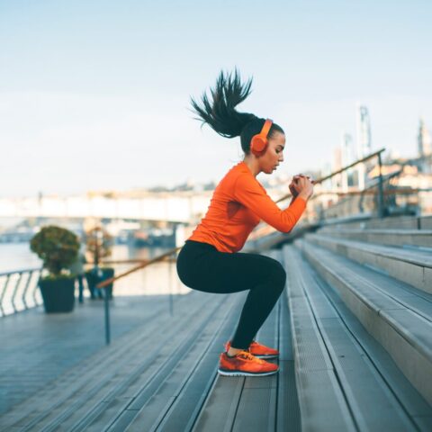 Woman jumping steps on a river bank.