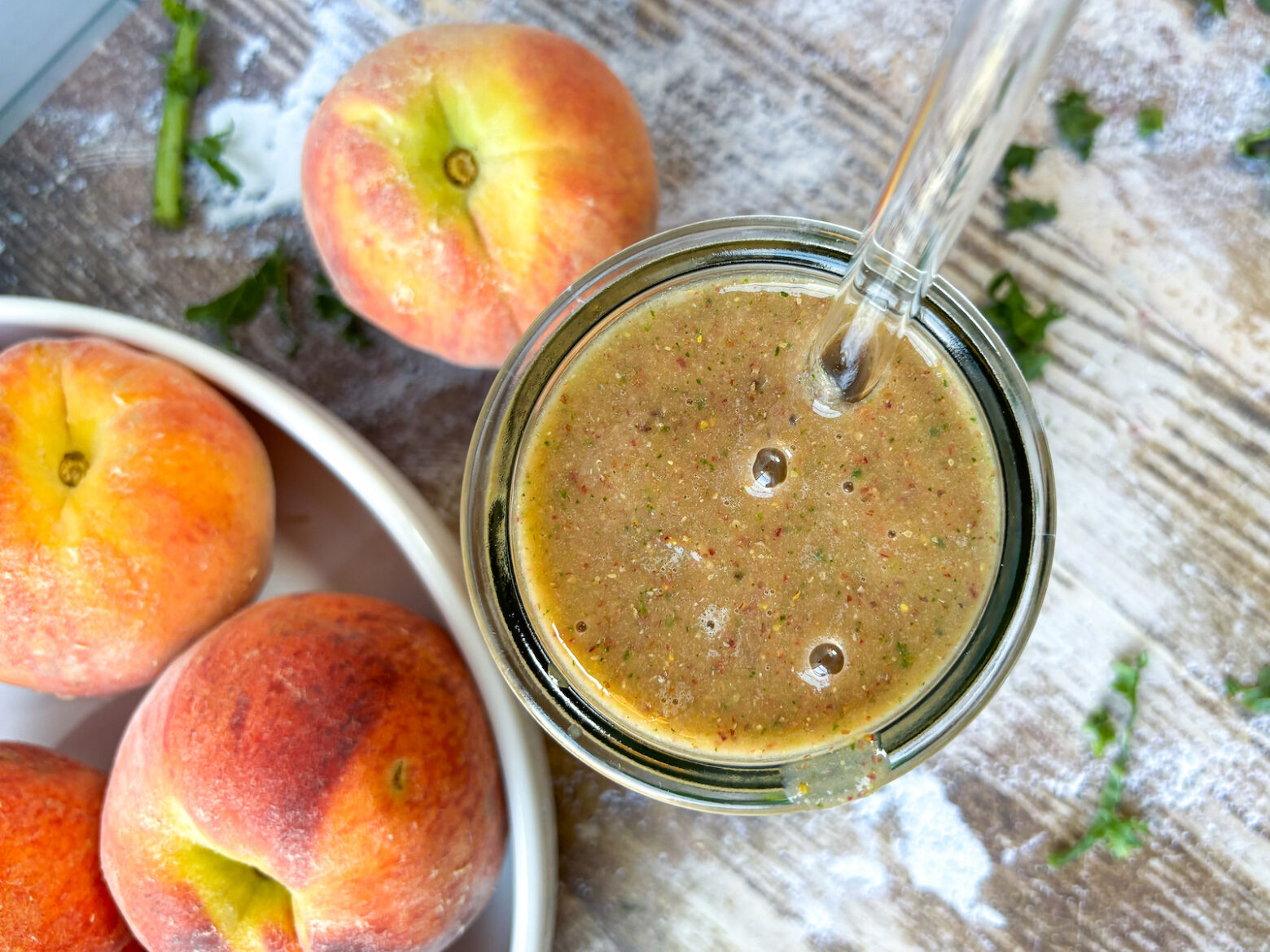 Finished smoothie bird eye view with peaches and kale garnish in the background